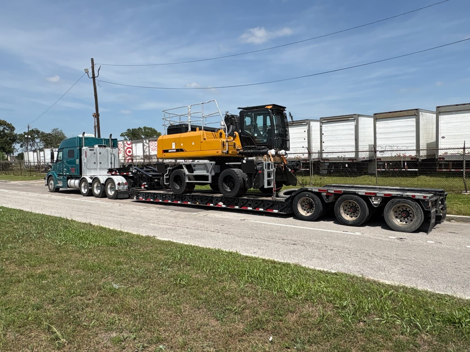 Excavator on a lowboy trailer being hauled down the highway