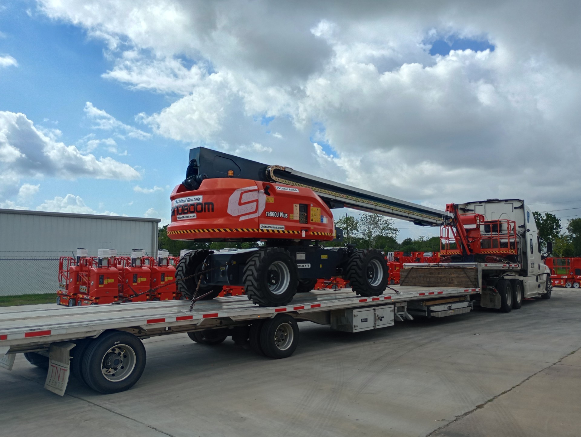 Stepdeck trailer transporting an aerial boom lift
